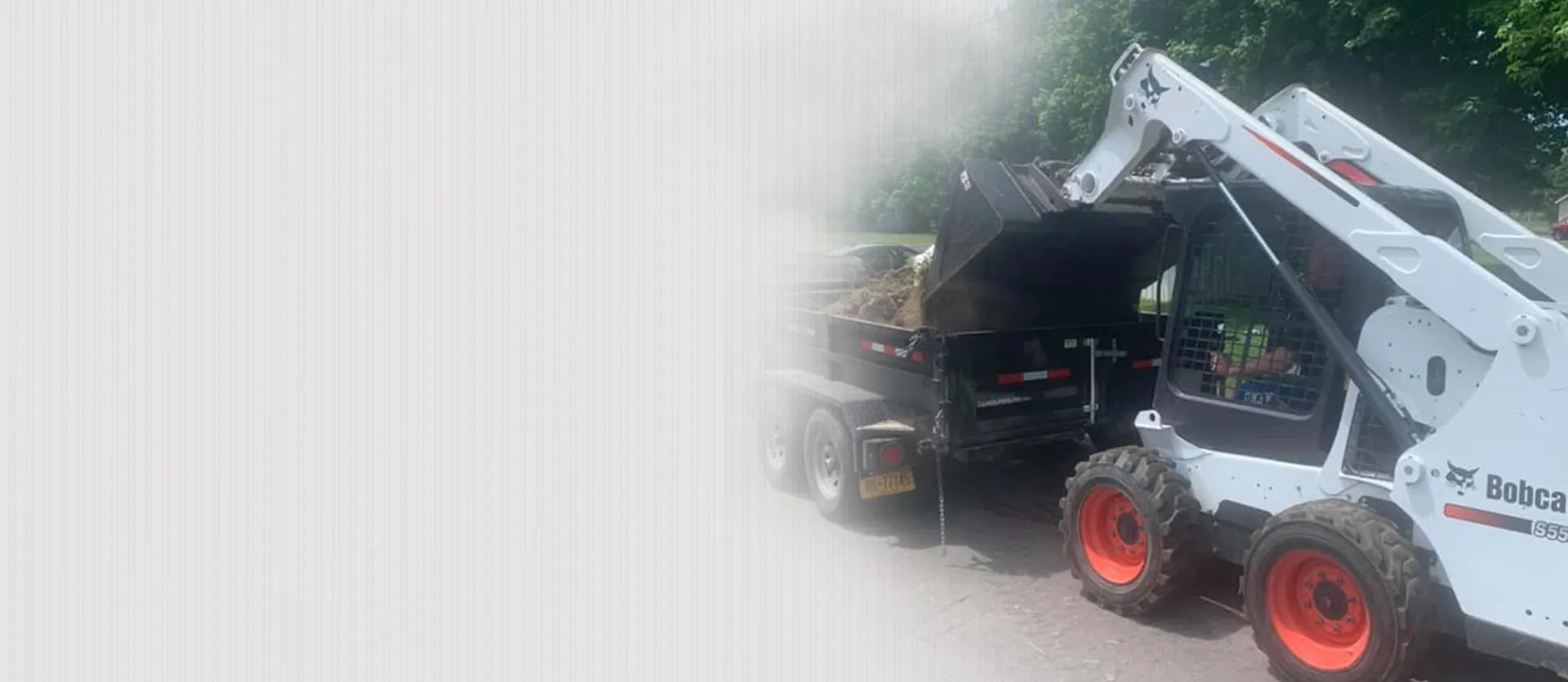 Bobcat skid steer loader dumping materials into truck during excavation